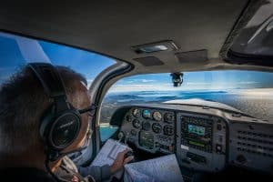 A pilot using charts to conduct a navigation exercise along the coast.